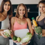 Smiling trio holding corn and lettuce
