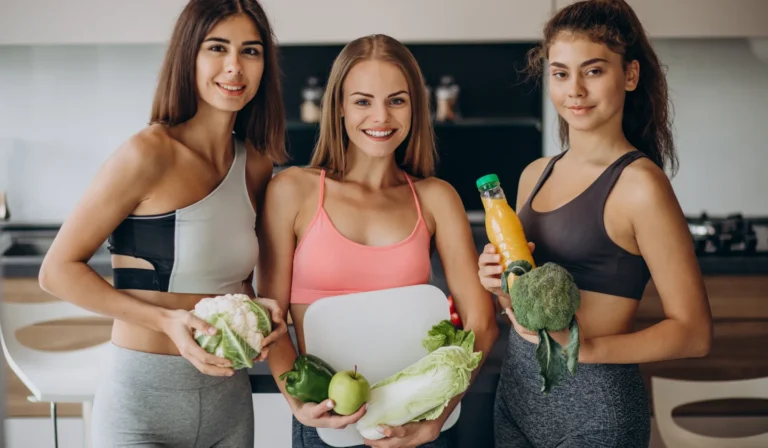 Smiling trio holding corn and lettuce
