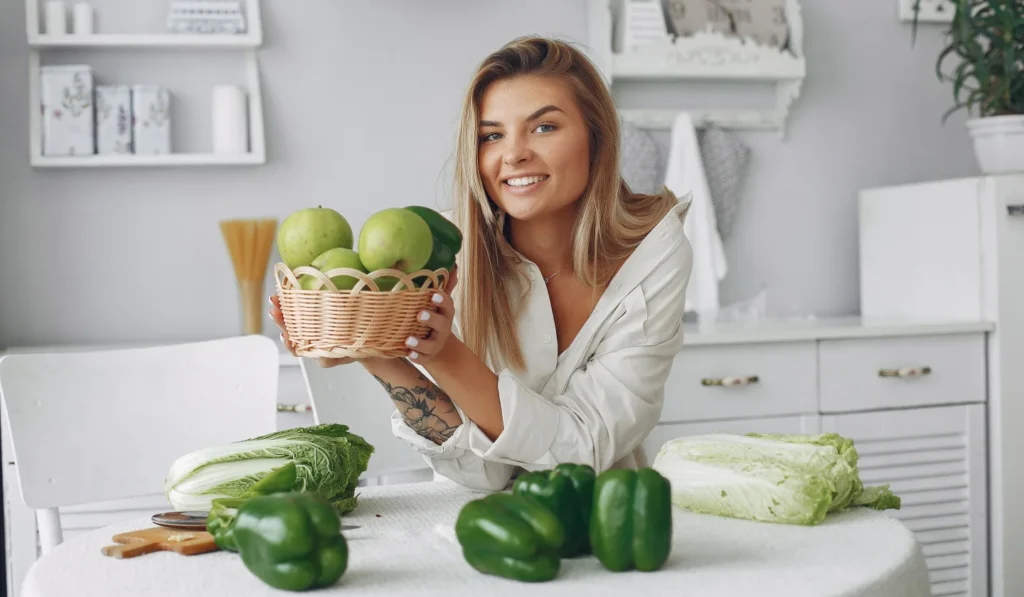 Smiling woman holding yellow tulips on cozy bed