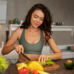Woman in red activewear holding fresh salad bowl