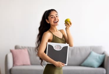 Woman cuddles small dog in bright modern living room