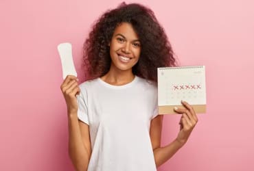 Smiling woman with curls holds blank notebook