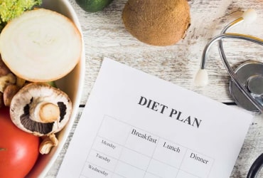 Person with grocery list amid fresh fruits & vegetables