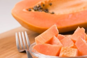 Person cuddling tiny fluffy orange kitten