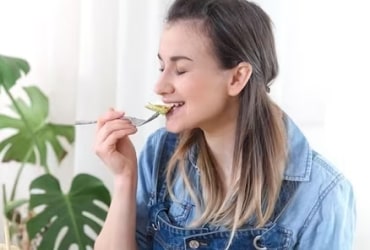 Smiling person on phone amid soft green blur