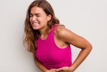 Long-haired person in pink top posing sideways