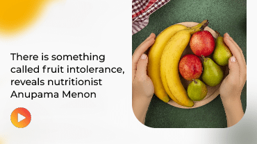 Hand holding colorful fruit bowl on green backdrop