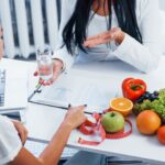 Person working at table with fruit bowl