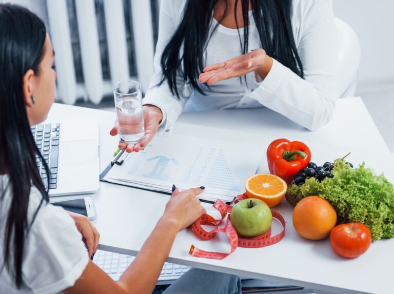 Person working at table with fruit bowl